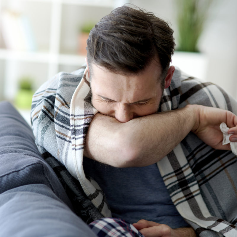 Man coughing into his elbow