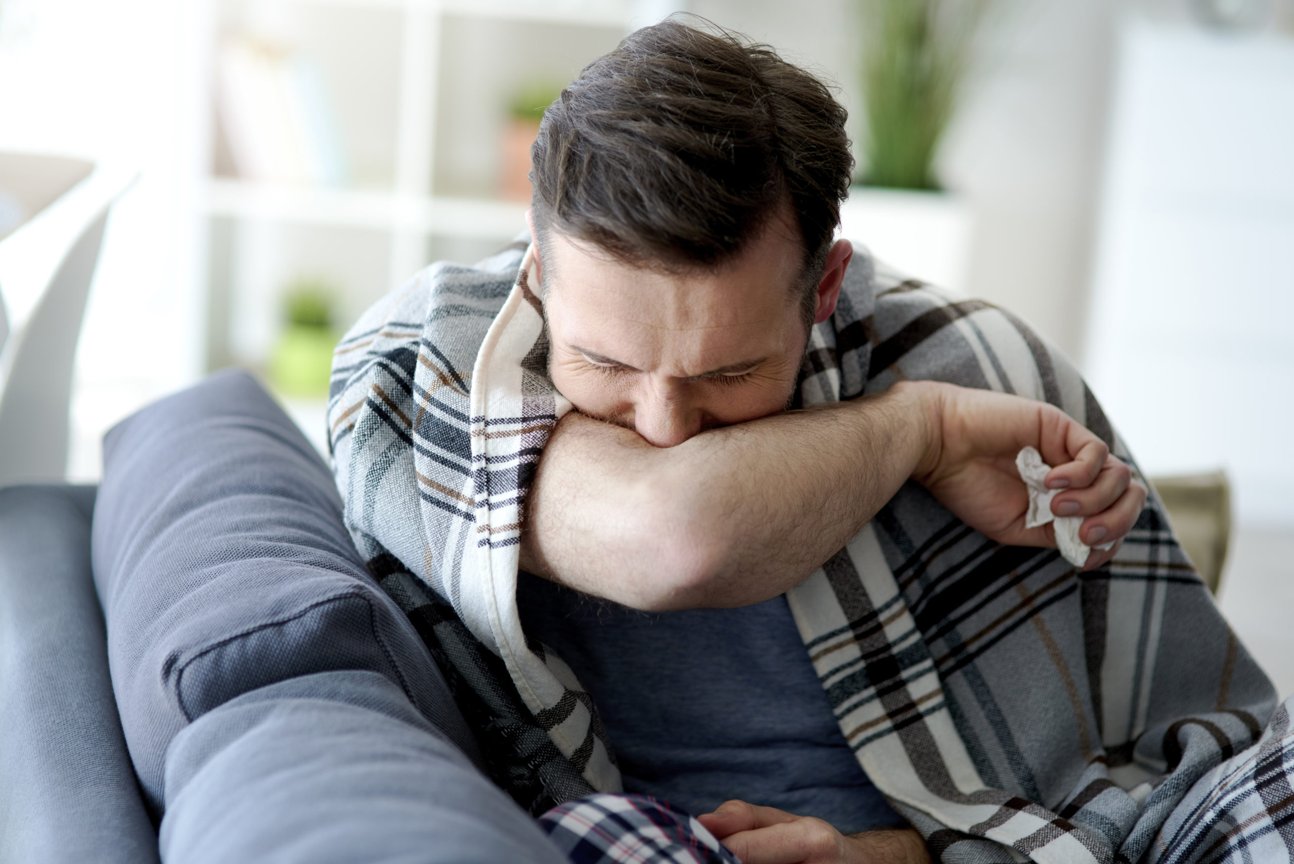 Man coughing into his elbow